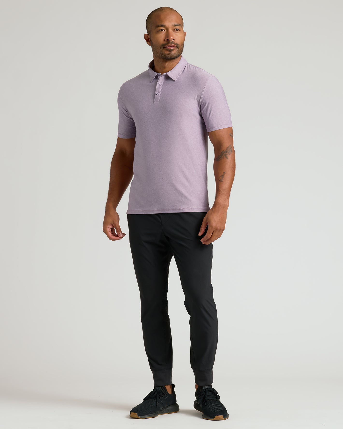 Man wearing Iris Active Polo 2.0, slim-fit pants, athletic sneakers.