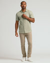 Man wearing Mossy Oak Short Sleeve Linen Shirt, beige chinos, white sneakers.