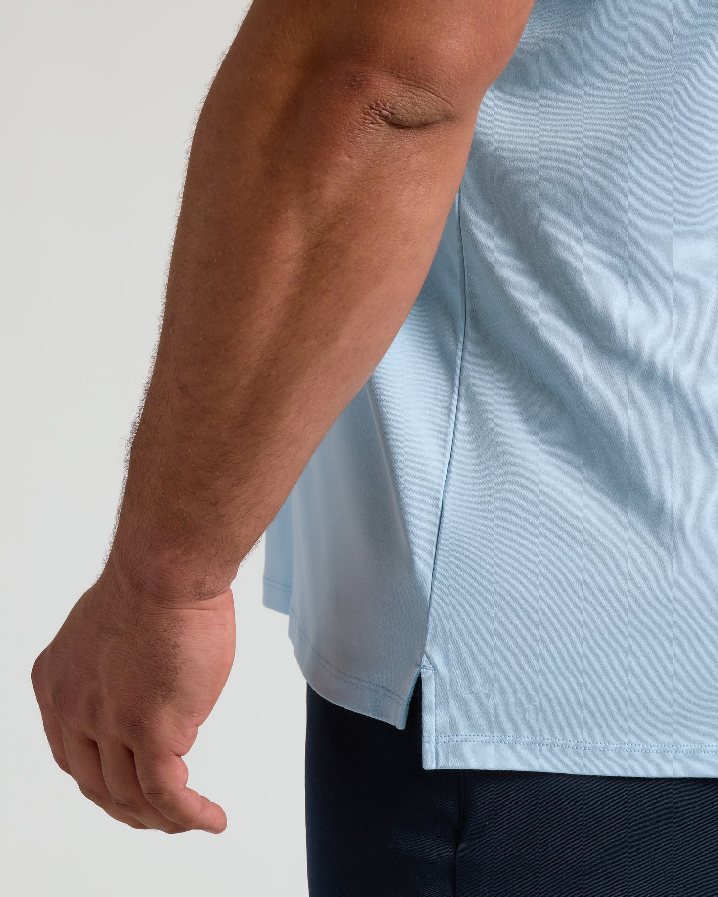 Close-up of Ether Premium Pima Polo's tailored sleeve and hem slit.