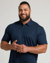 Muscular man wearing Premium Pima Polo 7-Pack in navy, smiling.