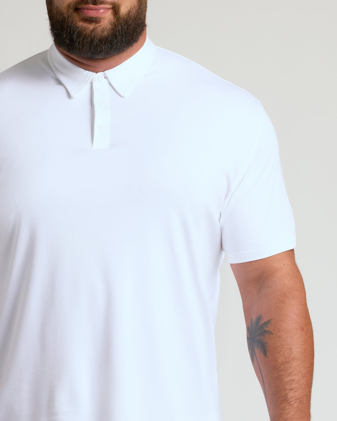 White Premium Pima Polo worn by man with palm-tree tattoo.