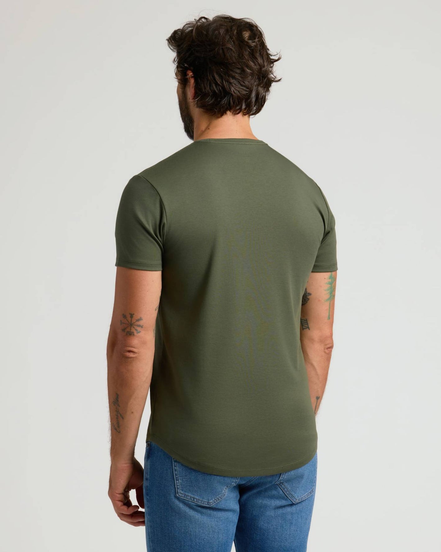Man wearing an olive green Pima Cotton Blend Curved Hem Crew 2-Pack t-shirt, shown from the back with short sleeves and paired with blue jeans, highlighting a casual men’s basics style.