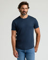 Man wearing Navy Premium Pima Crew Curved Hem T-shirt and jeans.