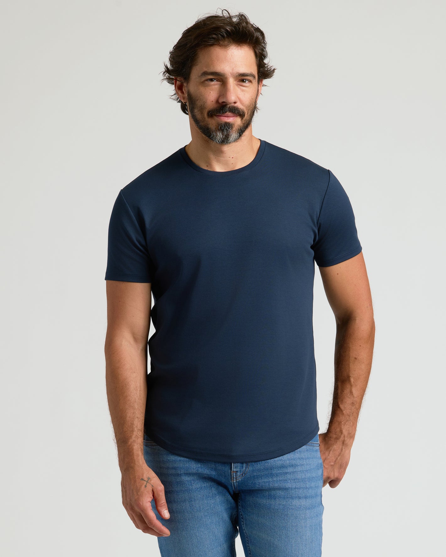 Man wearing Navy Premium Pima Crew Curved Hem T-shirt and jeans.