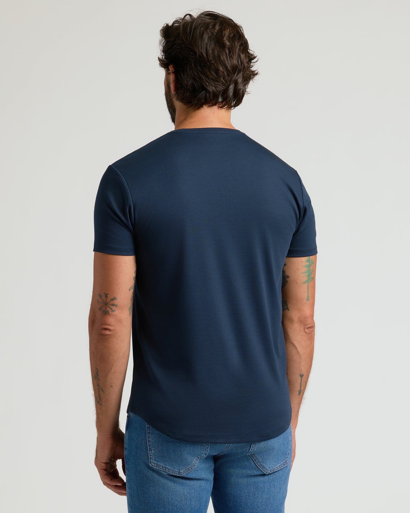 Man wearing Navy Premium Pima Crew Curved Hem Tee and jeans.