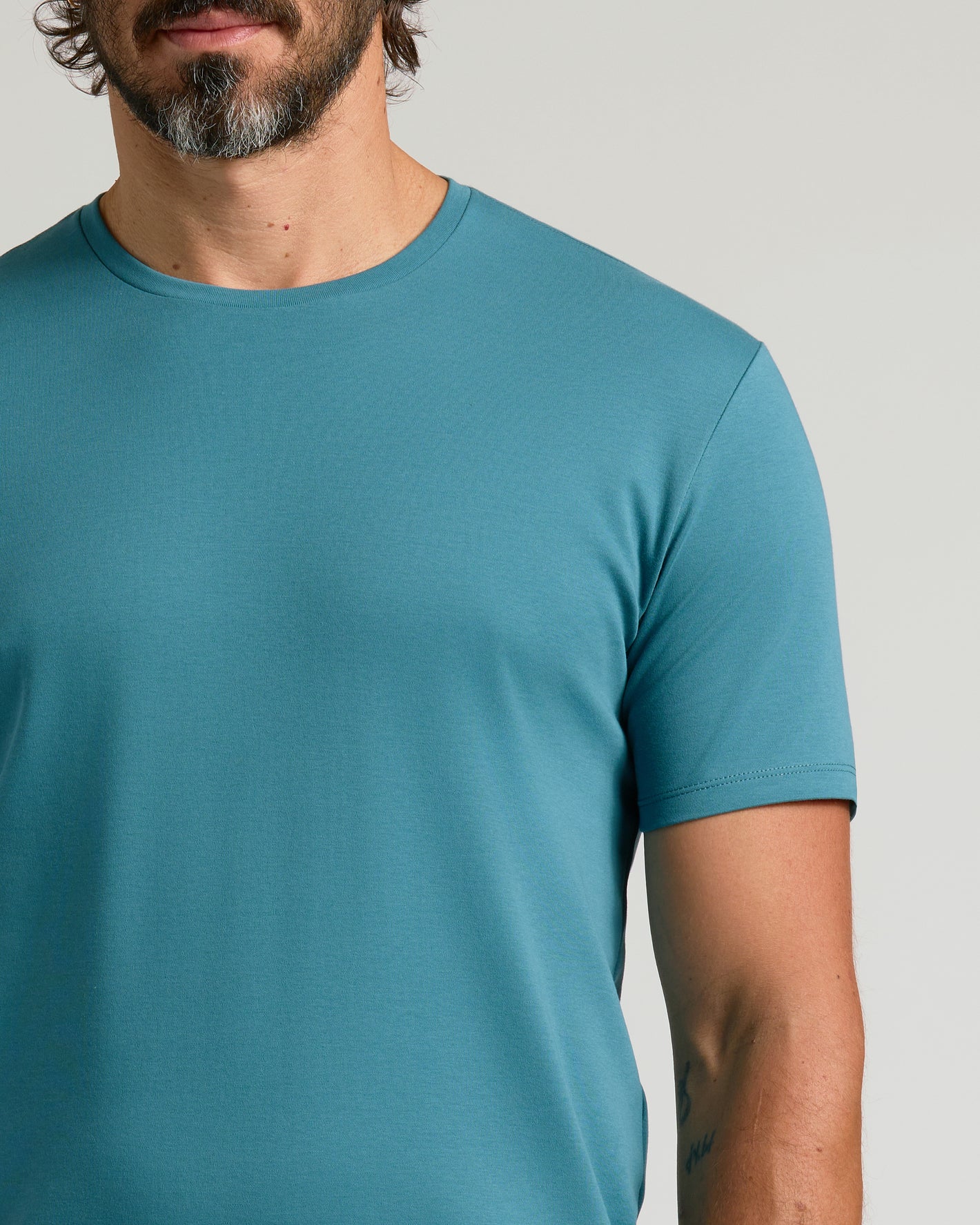 Sapphire Premium Pima Crew Neck on man with tattooed forearm.