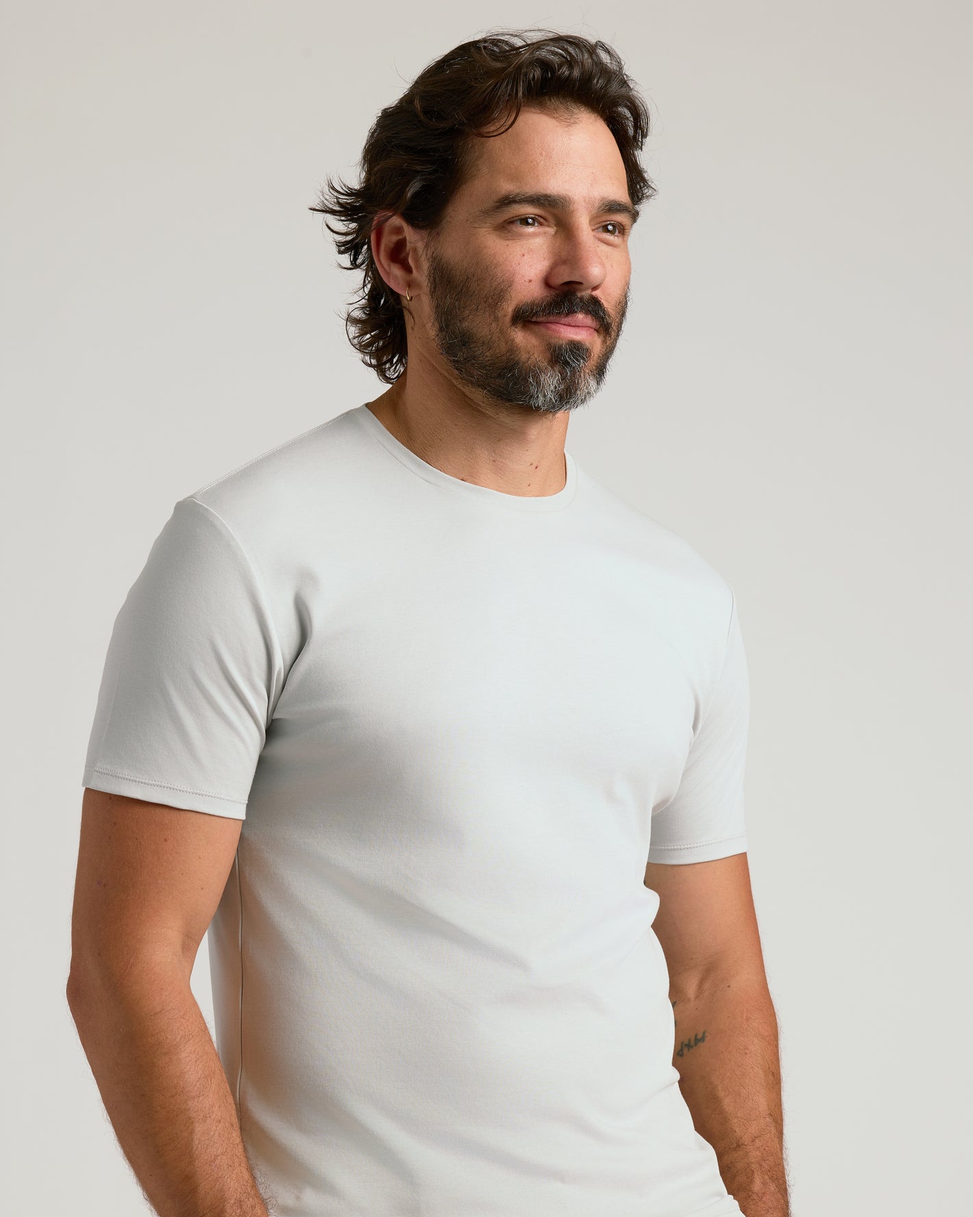 Man wearing Vapor Premium Pima Crew Neck, showcasing snug fit and sleek design.