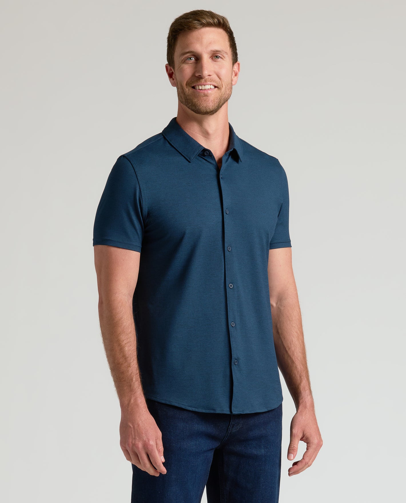 Man in Dark Heather Navy Short Sleeve Comfort Knit Shirt, relaxed pose.