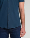 Man in Dark Heather Navy Short Sleeve Comfort Knit Shirt with jeans.