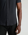 Man wearing Black Short Sleeve Comfort Knit Shirt with dark trousers.