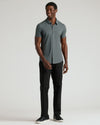 Man wearing Charcoal Heather Gray Short Sleeve Comfort Knit Shirt, black pants, sneakers.