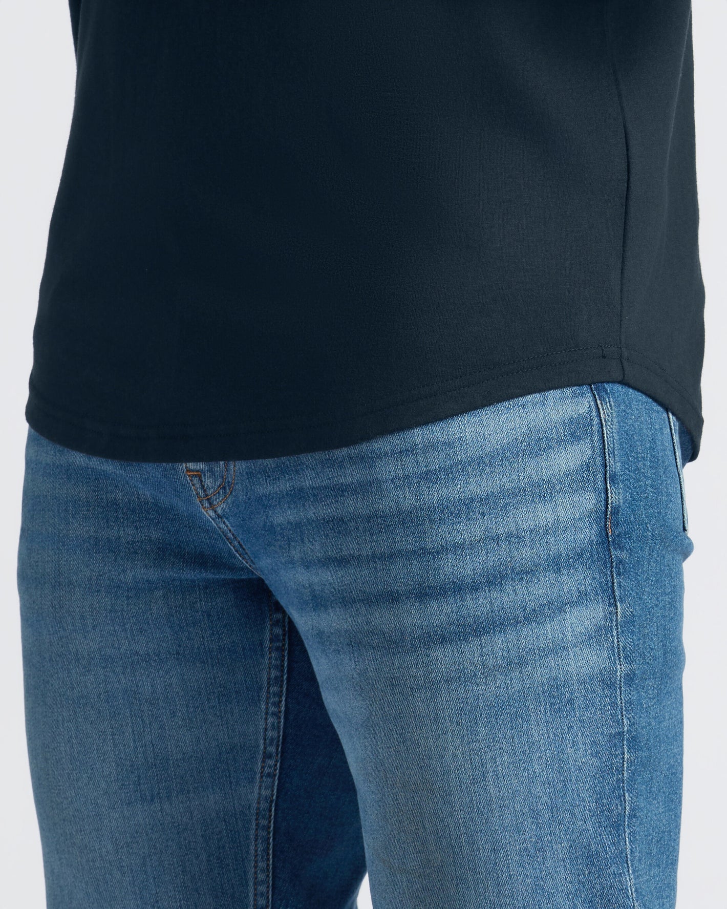 Close-up of blue jeans and a black shirt on a white background