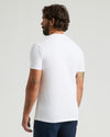 Man wearing a plain white t-shirt on a light gray background