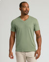 Man wearing Dark Heather Bay Green Classic V-Neck and beige trousers.