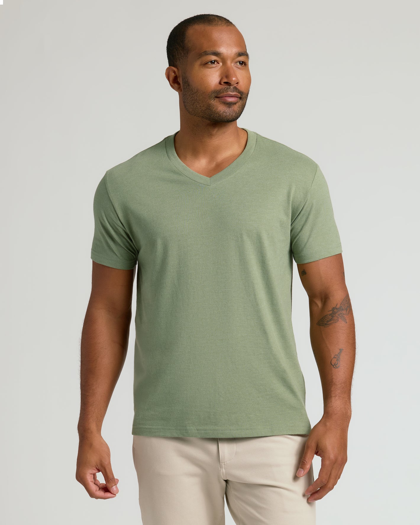 Man wearing Dark Heather Bay Green Classic V-Neck and beige trousers.