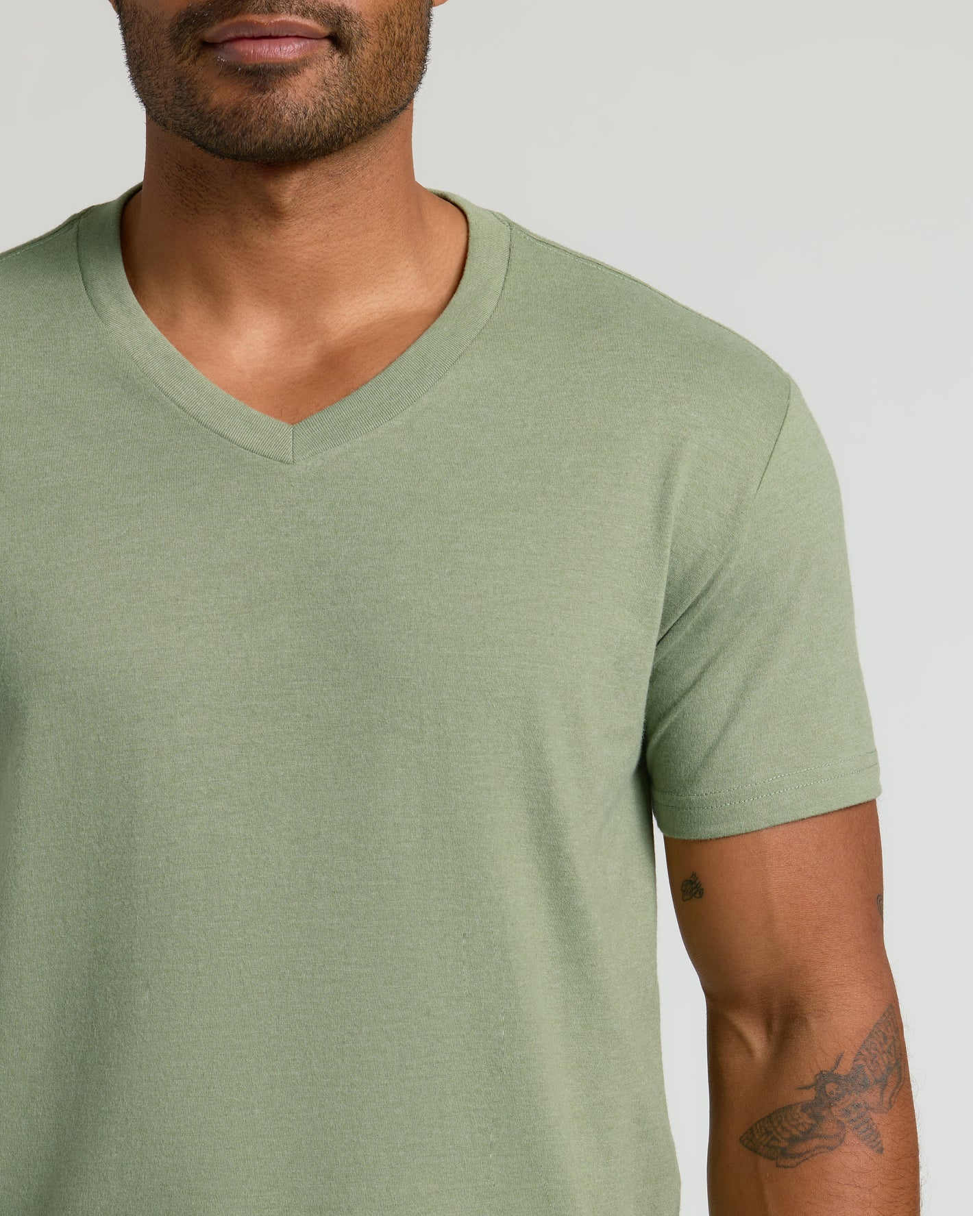 Man wearing Dark Heather Bay Green Classic V-Neck, showing tattoos.