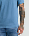 Dark Heather Blue Lake V Neck Tee showcasing tattoos on arm.