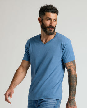 Man in Dark Heather Blue Lake V Neck Tee, showcasing fit and tattoos.