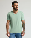 Man in Heather Slate Green Classic V-Neck and medium-wash jeans.