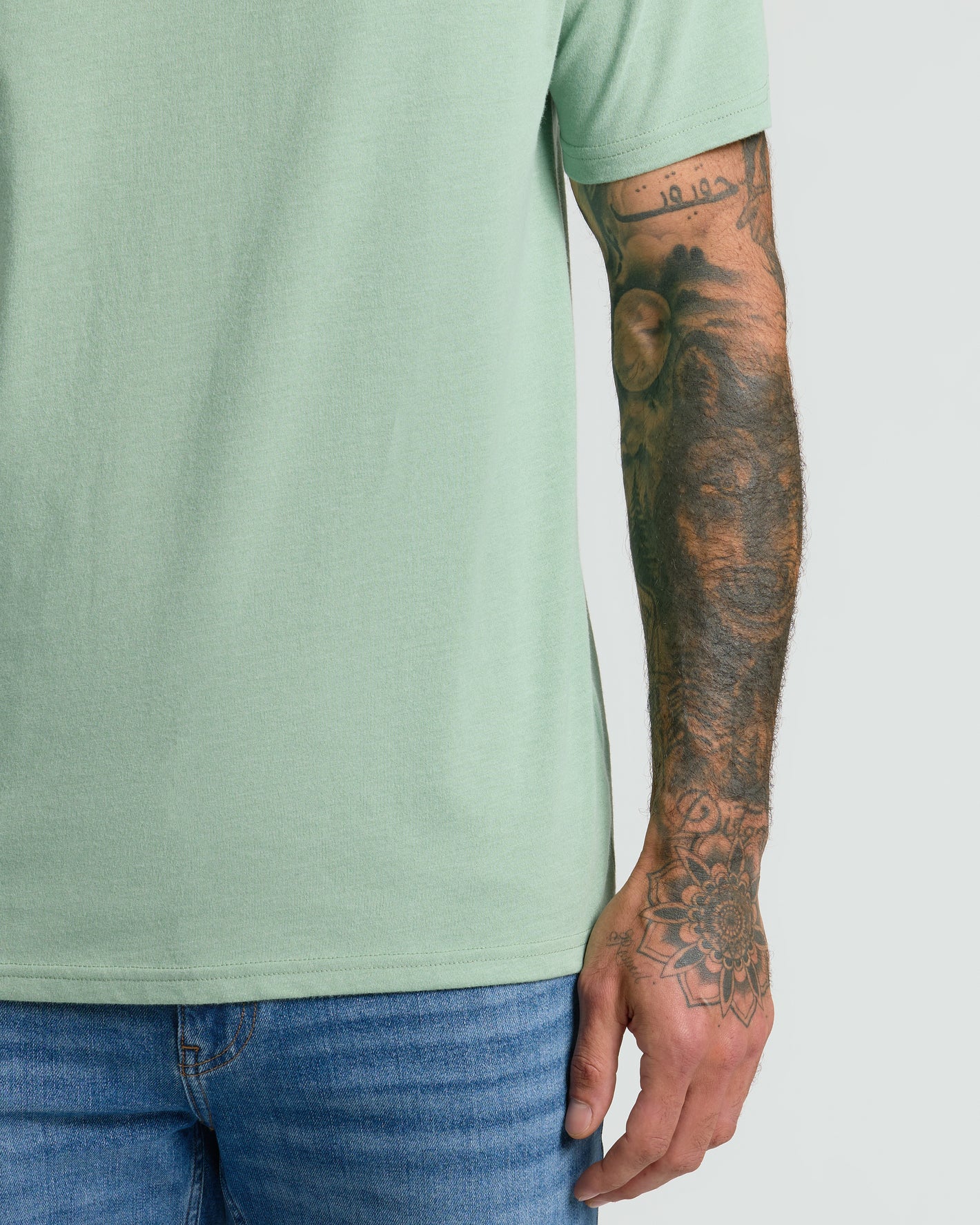Heather Slate Green Classic V-Neck showcasing tattooed forearm.