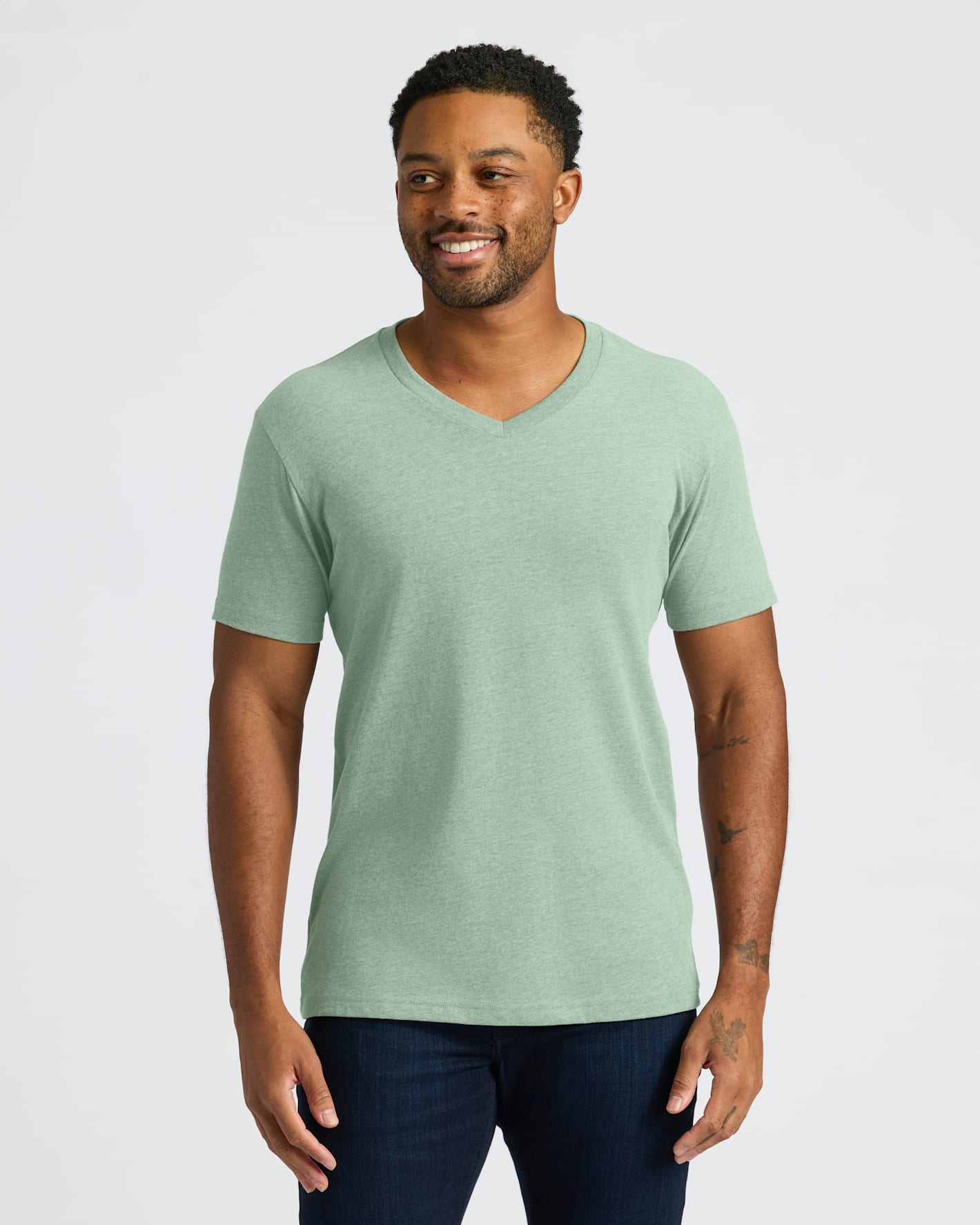Man wearing a green V-neck t-shirt against a plain background