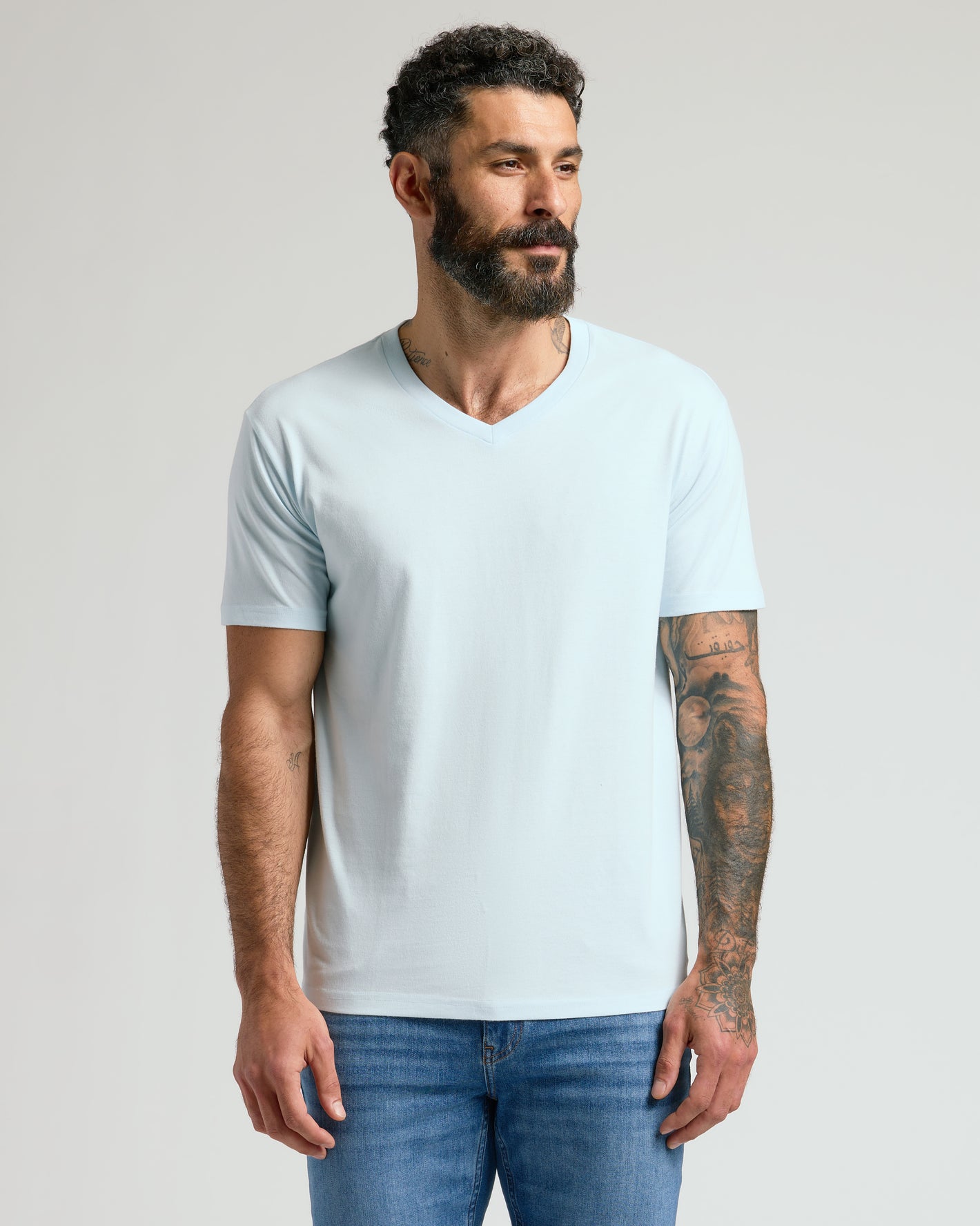 Man wearing Icicle Classic V-Neck, showcasing its fitted style and tattooed arms.