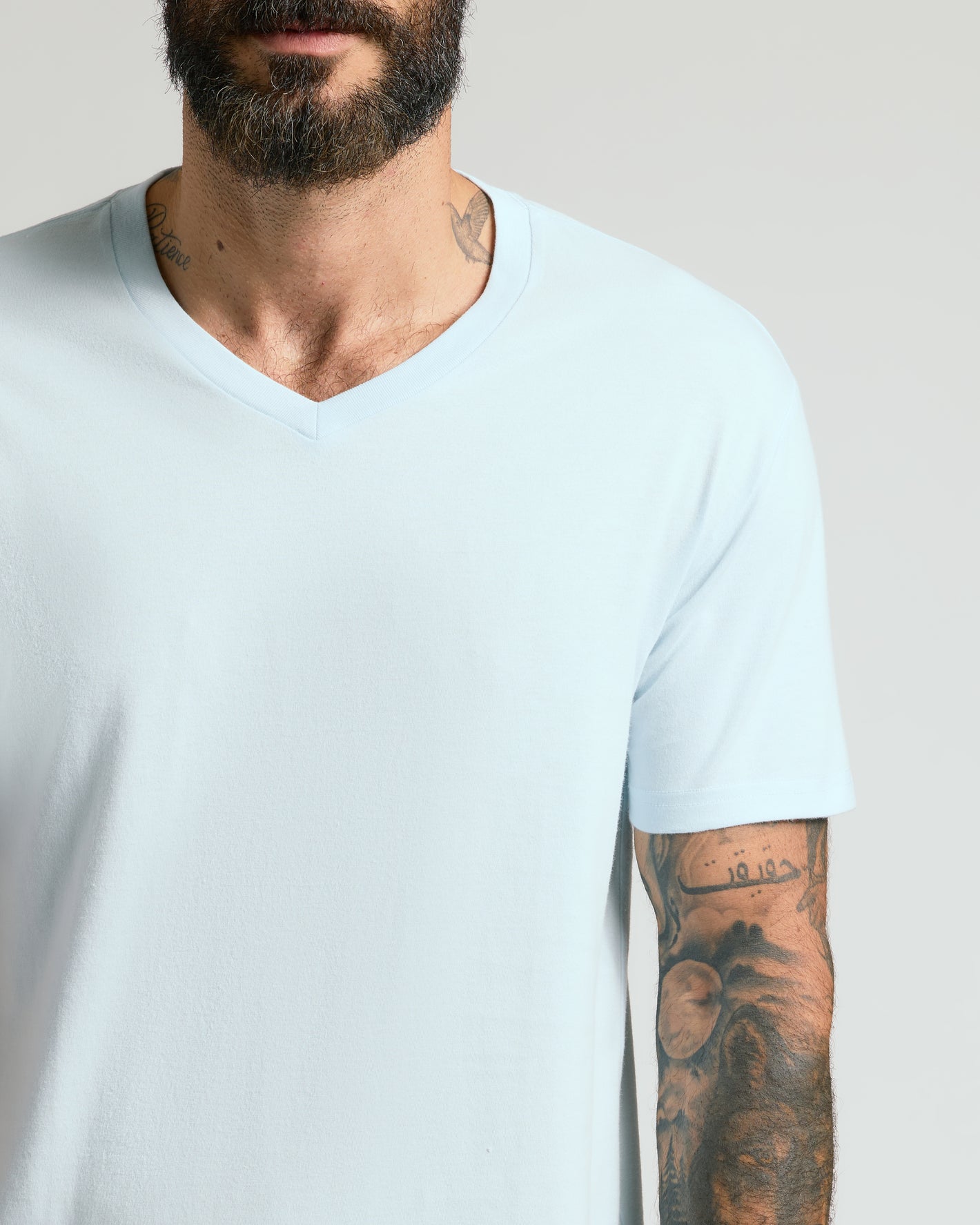 Icicle Classic V-Neck on tattooed man, showcasing fit and comfort.