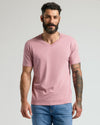 Man wearing Light Heather Boysenberry Classic V-Neck and jeans, neutral expression.