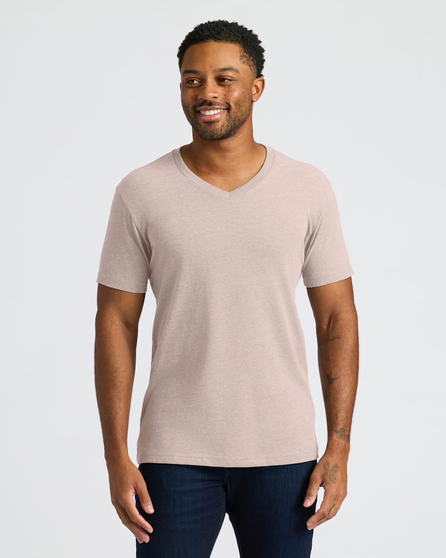 Man wearing a beige V-neck t-shirt against a plain background