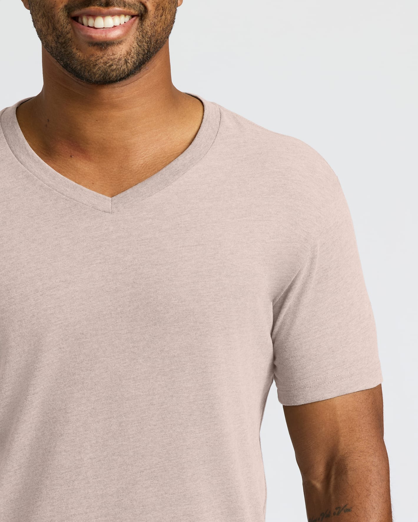 Man wearing Light Heather Slate Mauve Classic V-Neck T-shirt, smiling.