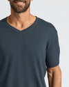 Man wearing a dark gray V-neck t-shirt on a light gray background