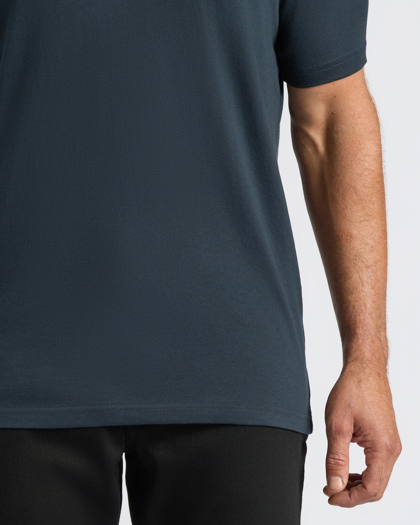 Person wearing a dark blue t-shirt on a light gray background