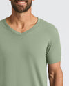 Man wearing a green V-neck t-shirt against a white background