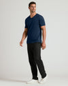 Man wearing Navy Premium Pima V-Neck, straight-leg black pants, white sneakers.