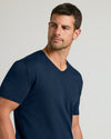 Young man in Navy Premium Pima V-Neck, gazing left.