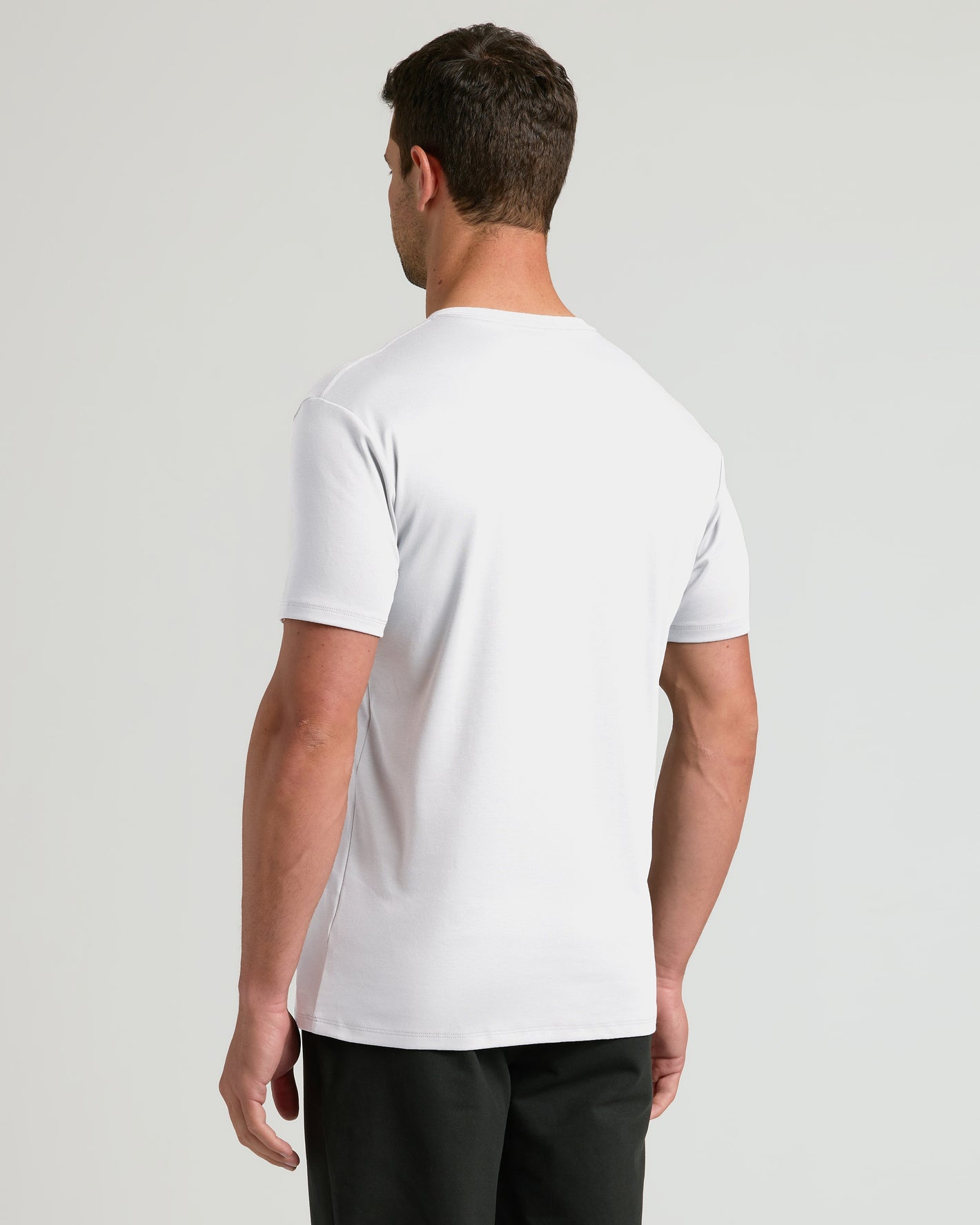 Man in Steel White Pima V-Neck T-shirt, relaxed pose.