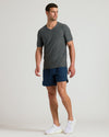 Man wearing Charcoal Heather Gray Active V-Neck, navy shorts, white sneakers.