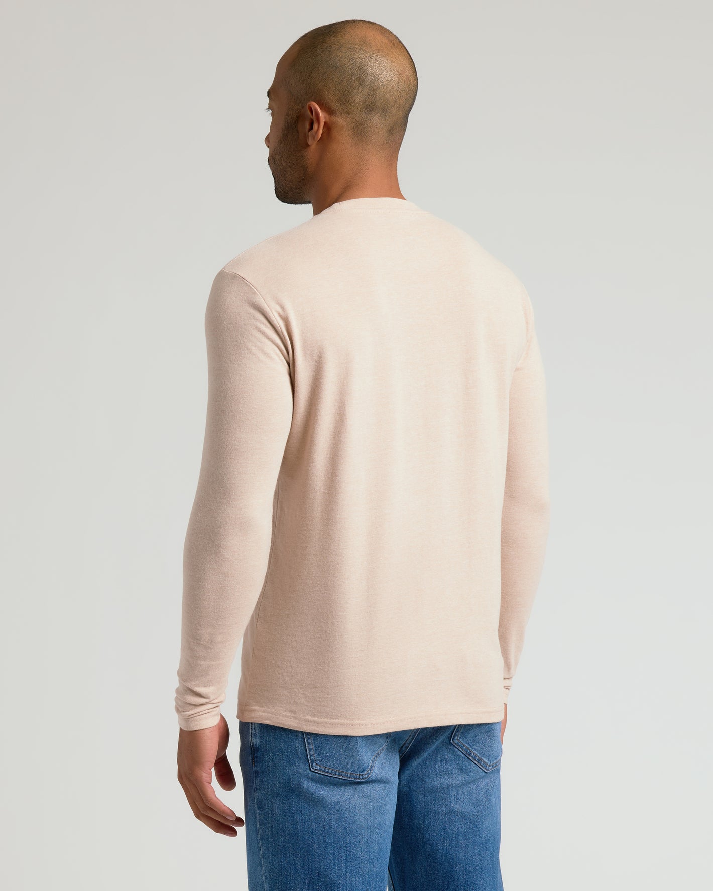 Man wearing Heather Camel Classic Long Sleeve Crew Neck with jeans.