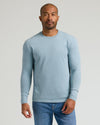 Man wearing Heather Sapphire Classic Long Sleeve Crew Neck and jeans.