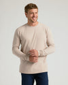 Man in beige Seasonal Classic Long Sleeve Crew, adjusting sleeve, jeans.