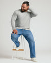 Man wearing Steel Classic Long Sleeve Crew Neck on stool, smiling.