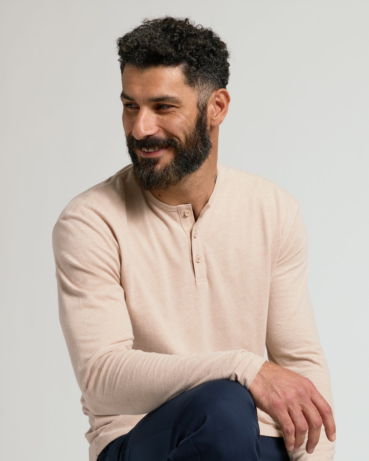 Man wearing Heather Camel Classic Long Sleeve Henley, relaxed pose.