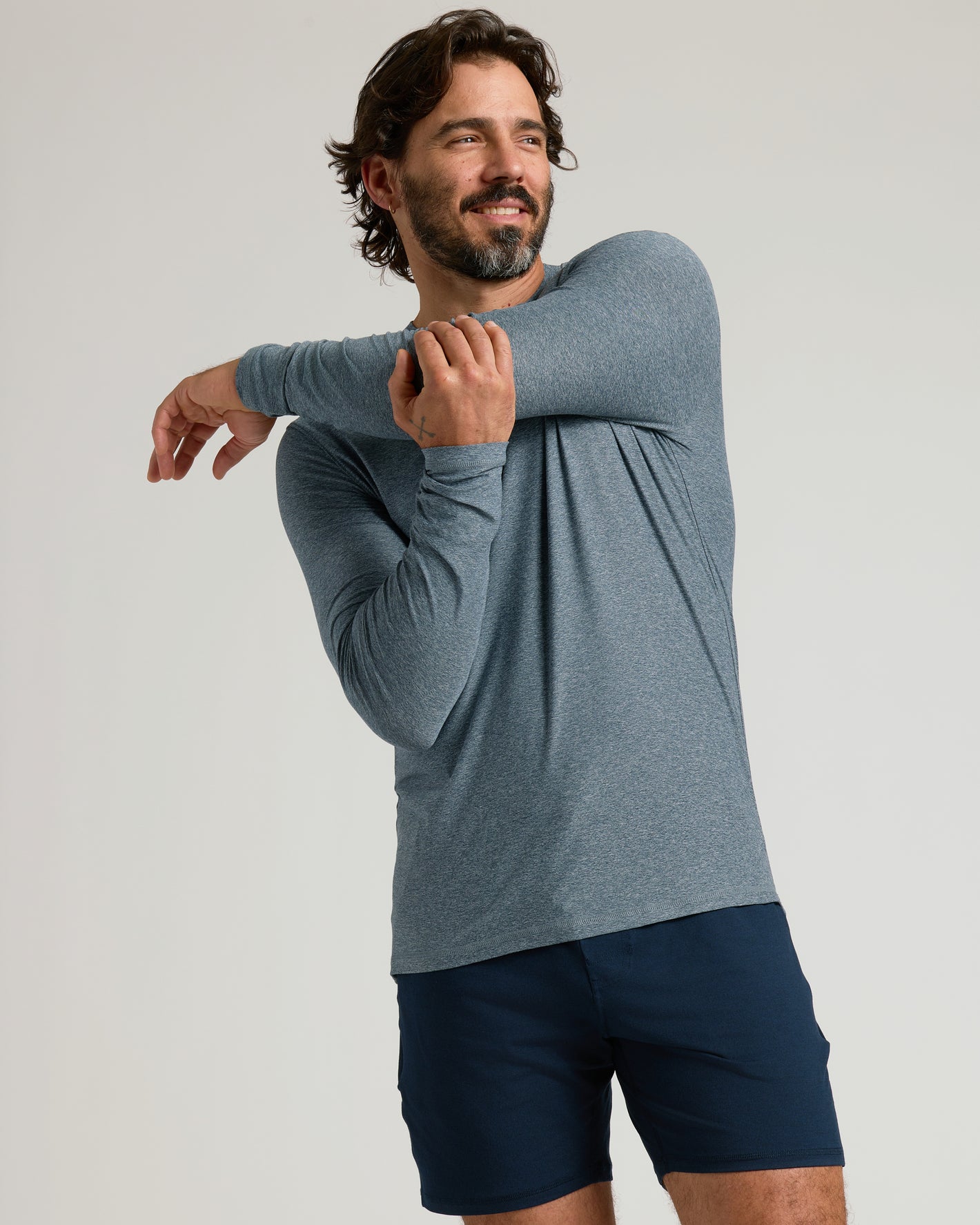Man wearing Active Long Sleeve Crew 3-Pack shirt stretching.