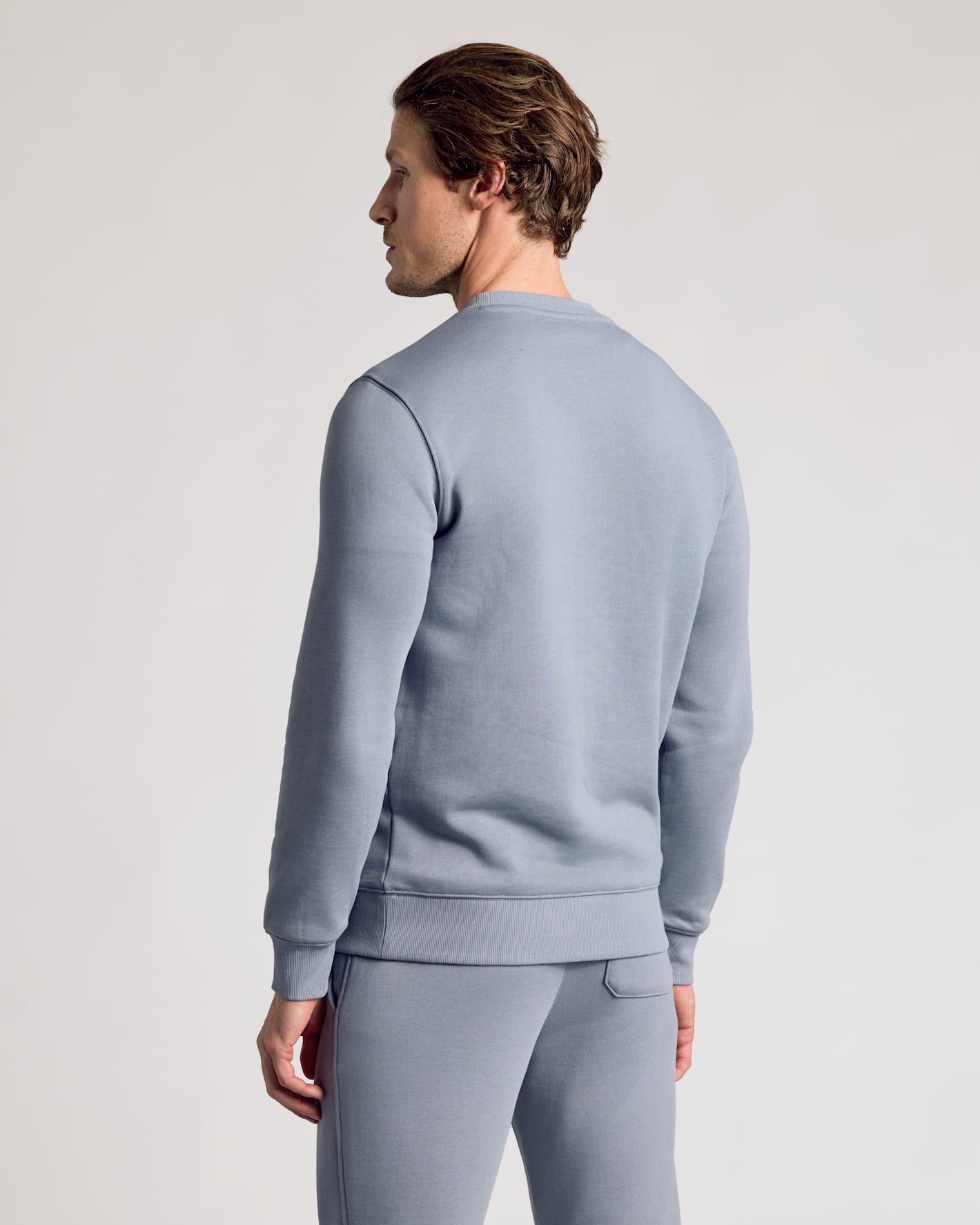 Person wearing Dusty Blue Fleece French Terry Pullover Crew Neck and matching sweatpants.