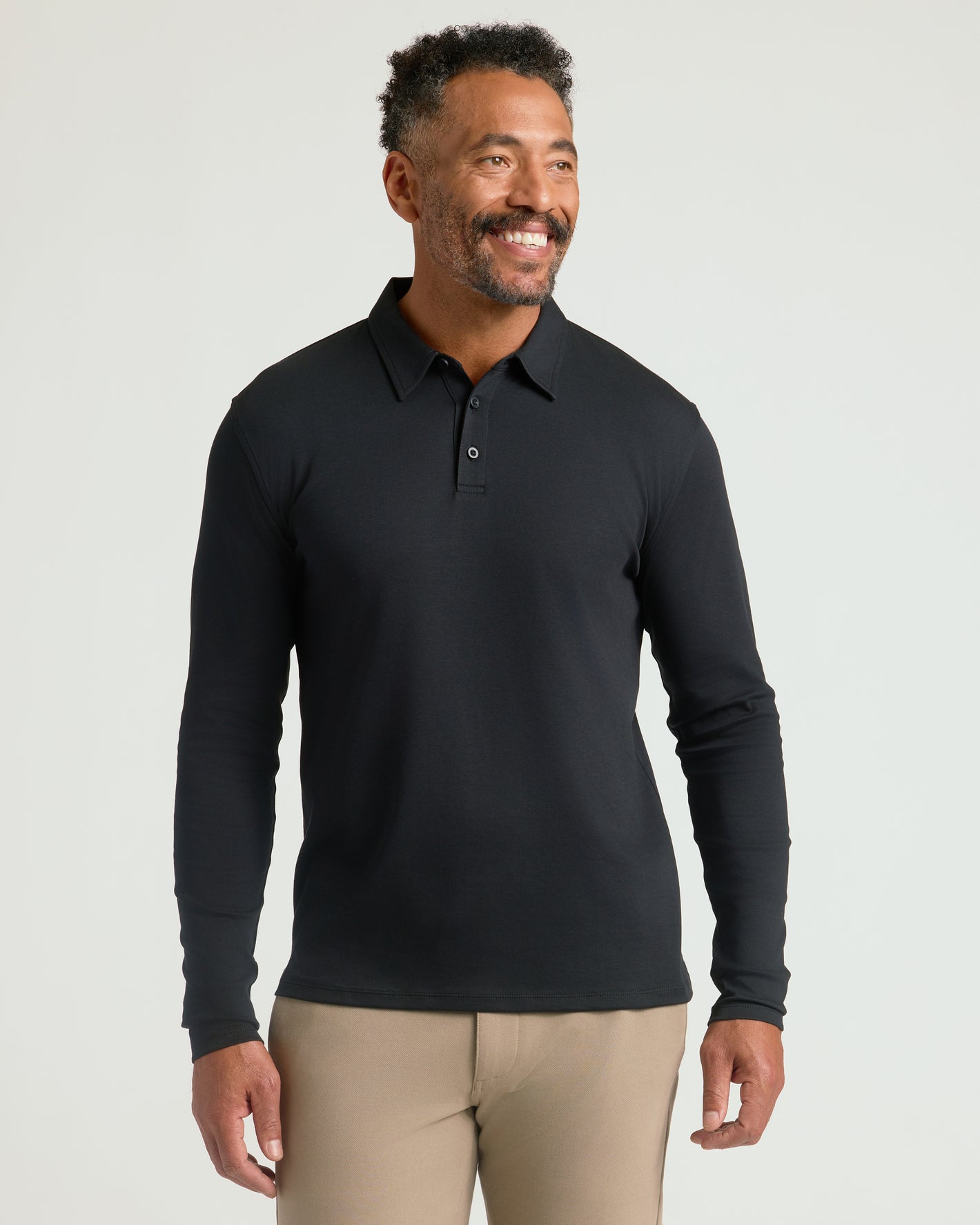 Man wearing Black Long Sleeve Premium Pima Polo, showcasing its fit.