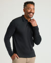 Man wearing All Black Long Sleeve Premium Pima Polo, beige trousers.