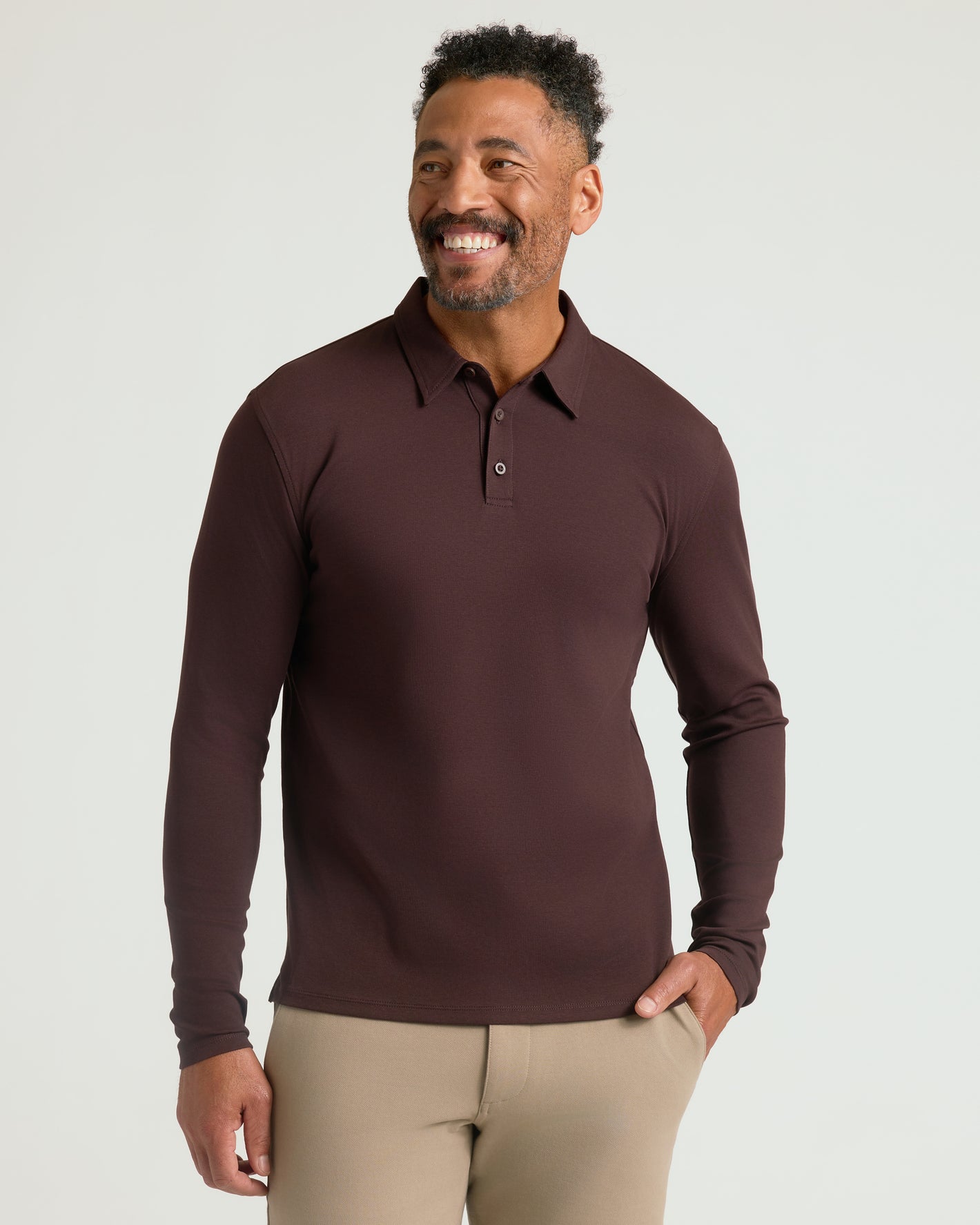 Model in All Java Long Sleeve Premium Pima Polo, smiling confidently.