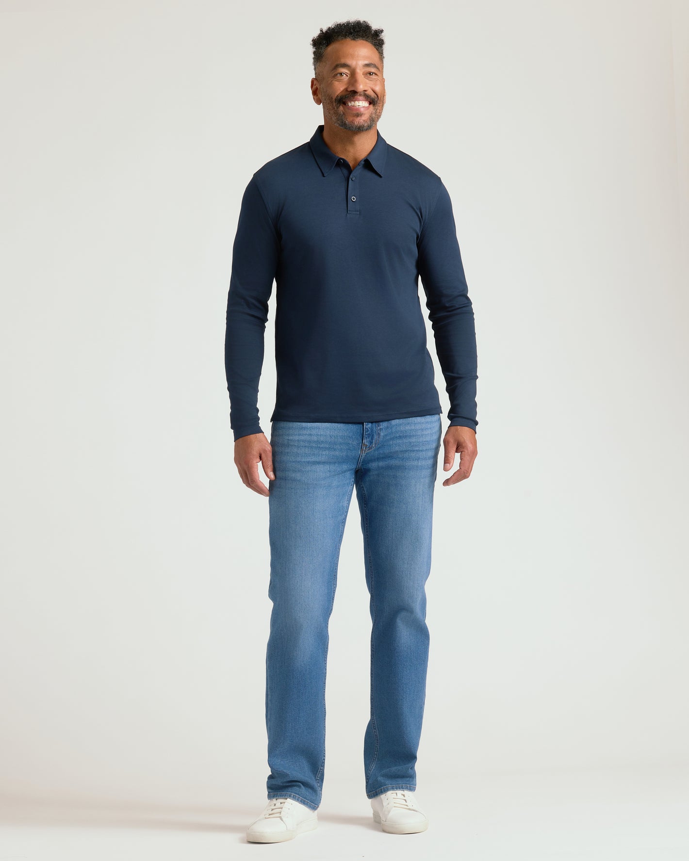 Man wearing All Navy Long Sleeve Premium Pima Polo, smiling.