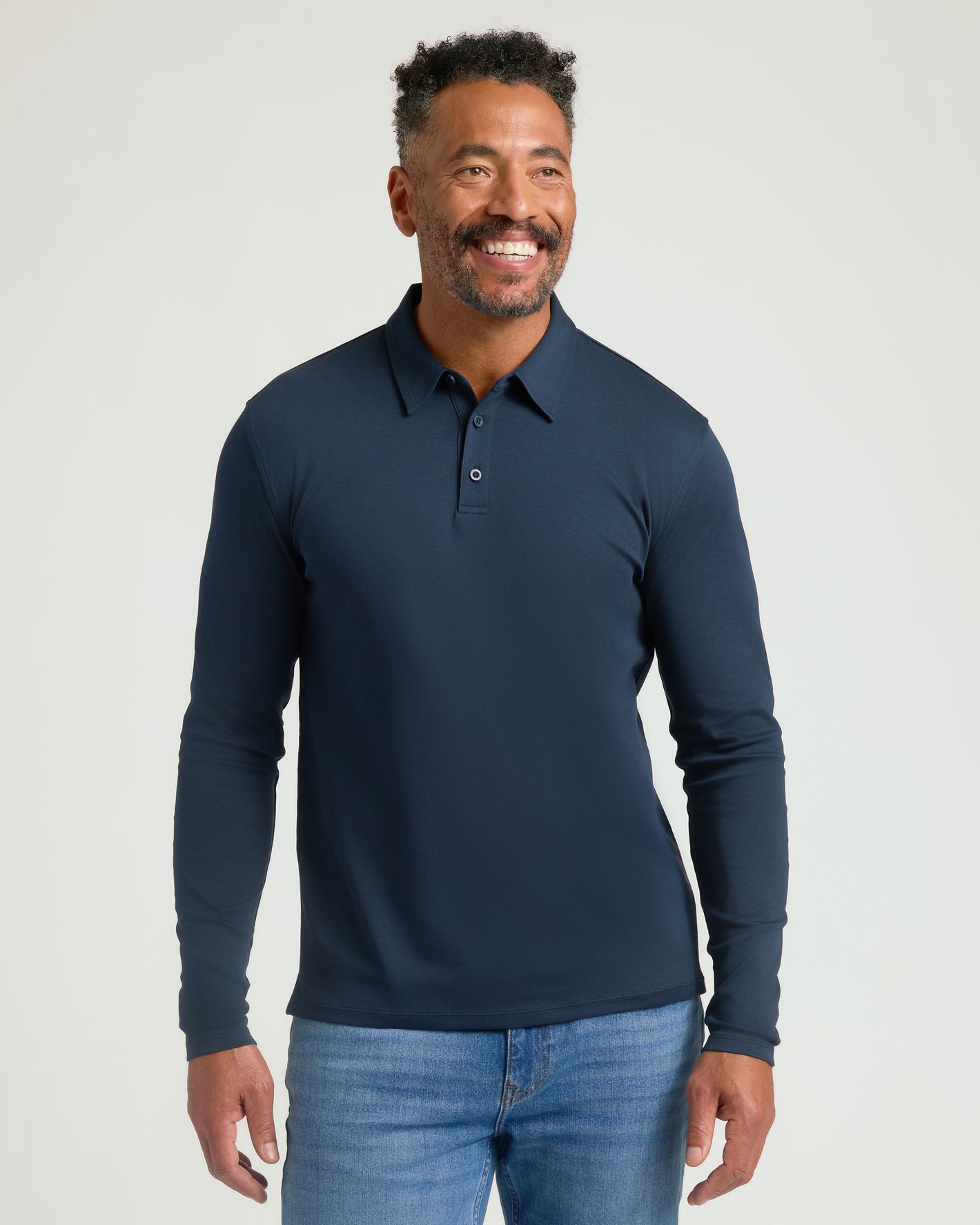 Man wearing All Navy Long Sleeve Premium Pima Polo, smiling.
