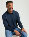 Man wearing All Navy Long Sleeve Premium Pima Polo, smiling comfortably.